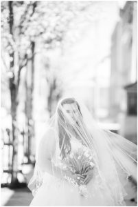 plus size couple in wedding attire taking wedding photos in downtown portland maine holding tulips