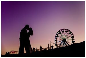 sunset portrait of a couple engagement at old orchard pier amusement park