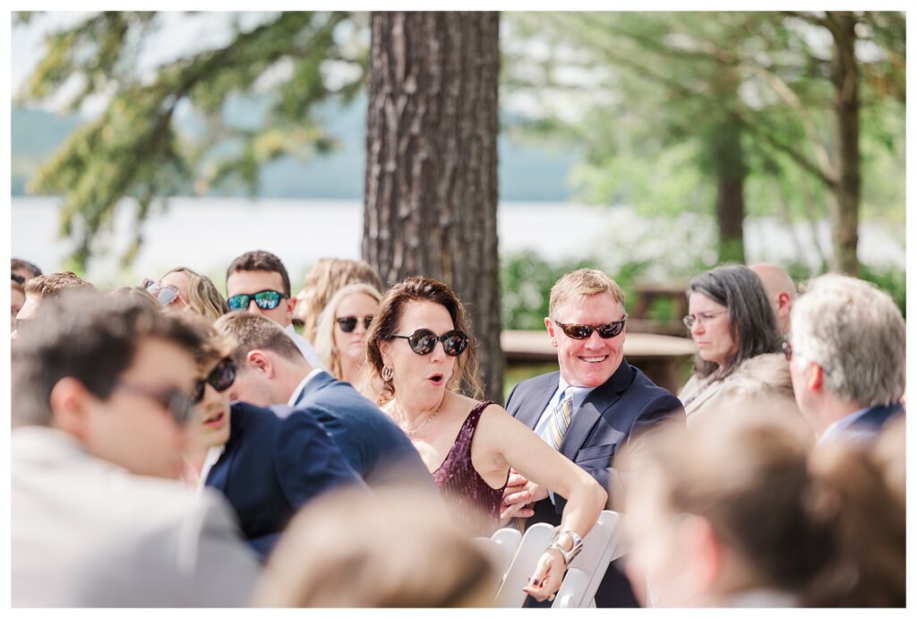 bride and groom get married at wedding venue tarry a while in bridgton maine. upscale luxury wedding with black tie groomsmen tuxes and black satin bridesmaid dresses, colorful flowers, summer maine wedding, lake, tent, outdoor dance floor, destination wedding