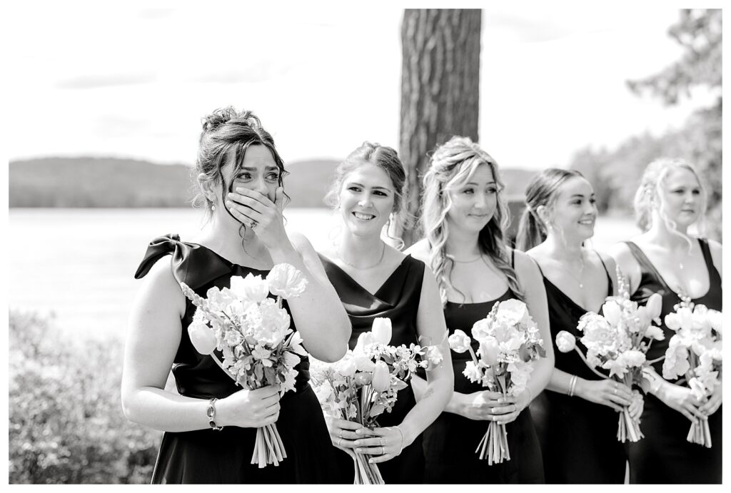 bride and groom get married at wedding venue tarry a while in bridgton maine. upscale luxury wedding with black tie groomsmen tuxes and black satin bridesmaid dresses, colorful flowers, summer maine wedding, lake, tent, outdoor dance floor, destination wedding