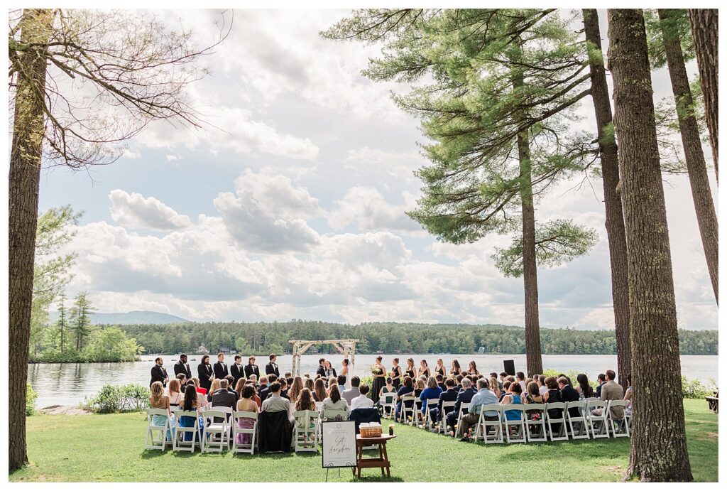 bride and groom get married at wedding venue tarry a while in bridgton maine. upscale luxury wedding with black tie groomsmen tuxes and black satin bridesmaid dresses, colorful flowers, summer maine wedding, lake, tent, outdoor dance floor, destination wedding