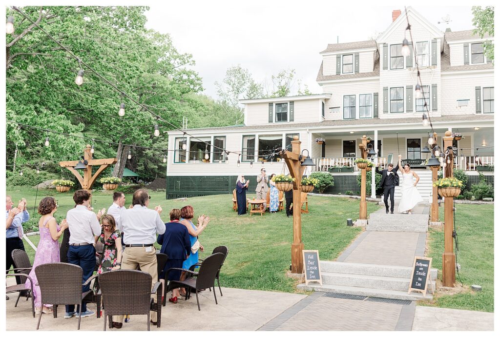 bride and groom get married at wedding venue tarry a while in bridgton maine. upscale luxury wedding with black tie groomsmen tuxes and black satin bridesmaid dresses, colorful flowers, summer maine wedding, lake, tent, outdoor dance floor, destination wedding