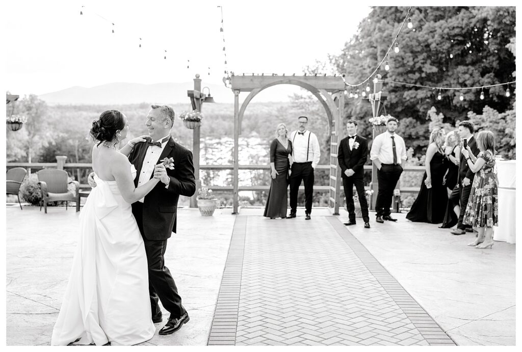 bride and groom get married at wedding venue tarry a while in bridgton maine. upscale luxury wedding with black tie groomsmen tuxes and black satin bridesmaid dresses, colorful flowers, summer maine wedding, lake, tent, outdoor dance floor, destination wedding