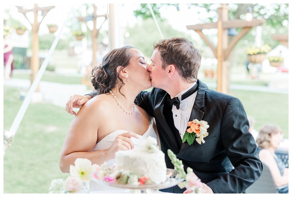 bride and groom get married at wedding venue tarry a while in bridgton maine. upscale luxury wedding with black tie groomsmen tuxes and black satin bridesmaid dresses, colorful flowers, summer maine wedding, lake, tent, outdoor dance floor, destination wedding