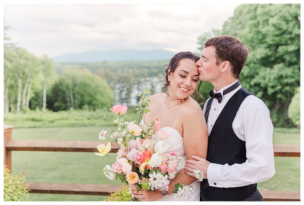 bride and groom get married at wedding venue tarry a while in bridgton maine. upscale luxury wedding with black tie groomsmen tuxes and black satin bridesmaid dresses, colorful flowers, summer maine wedding, lake, tent, outdoor dance floor, destination wedding