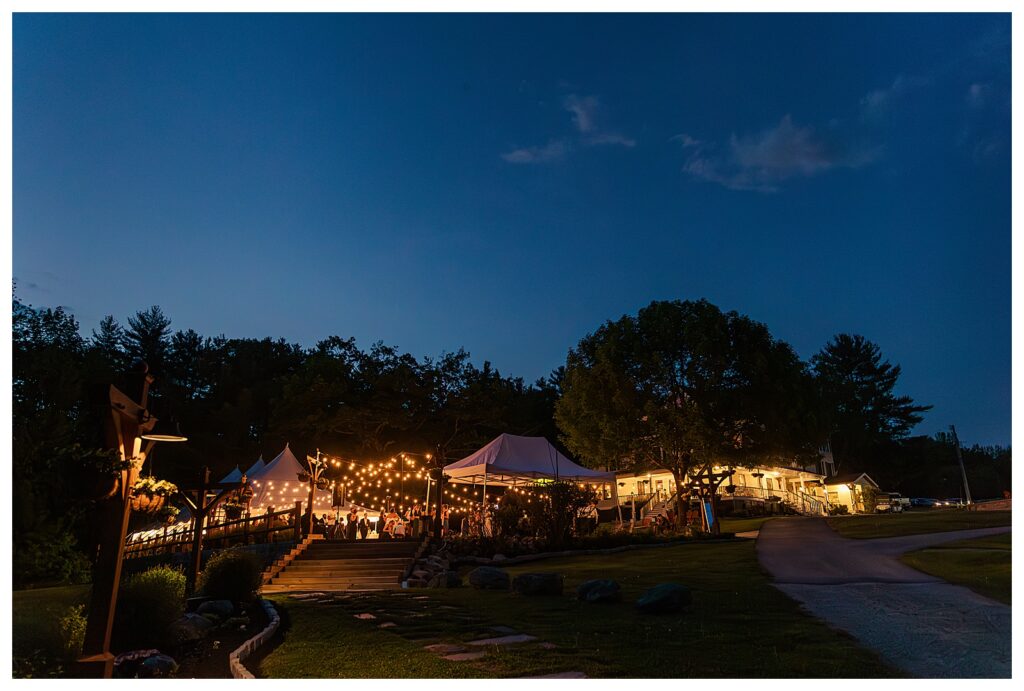 bride and groom get married at wedding venue tarry a while in bridgton maine. upscale luxury wedding with black tie groomsmen tuxes and black satin bridesmaid dresses, colorful flowers, summer maine wedding, lake, tent, outdoor dance floor, destination wedding